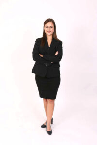 Portrait professionnel studio d'une femme en tailleur noir et jupe, bras croisés, en pied — galerie photo Agen Photo Minute
