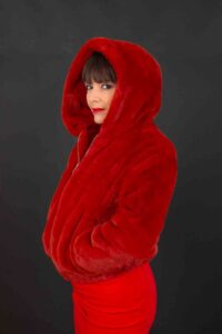 Portrait studio à Agen, femme en veste à capuche fourrure rouge, profil